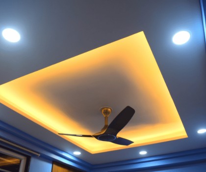 Modern false ceiling with LED lighting, layered textures, and a stylish finish.